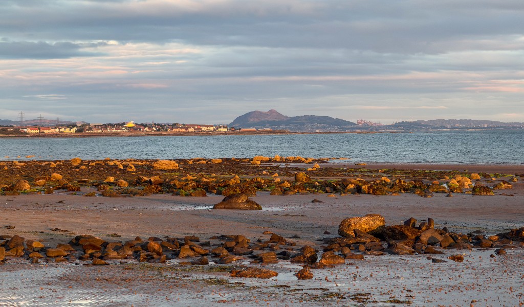 Rocky foreshore at Longniddry Bents looking across the Firth of Forth toward Edinburgh and Arthur's Seat